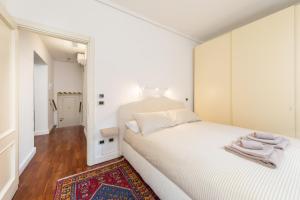 - une chambre blanche avec un grand lit et un tapis dans l'établissement COLOMBINA HOME Venice with canal view, à Venise