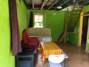 Habitación con paredes verdes, mesa y sillas. en 3 bedrooms house with sea view and furnished garden at Layou Valley Road, en Pont Cassé