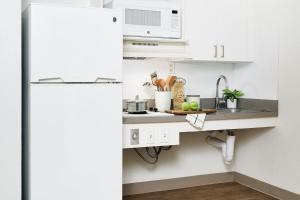 uma cozinha com um lavatório e um frigorífico branco em InTown Suites Extended Stay St. Louis MO - Hazelwood em Hazelwood
