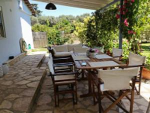 un patio con mesa, sillas y sofá en VILLA ANDRIANA, en Lefkada