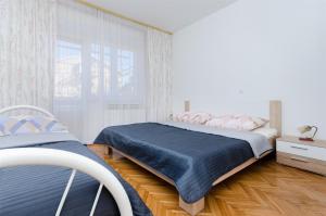 a bedroom with two beds and a window at Apartments Rezika in Mundanije