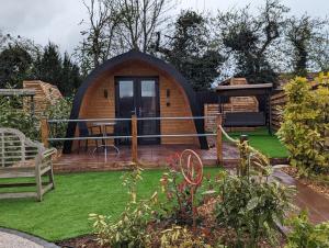 a small circular house with a yard with grass at Peacock Lake Glamping in Nottingham