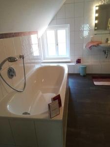 La salle de bains est pourvue d'une baignoire et d'une fenêtre. dans l'établissement Ferienwohnung am Kirchplatz 25561, à Weener