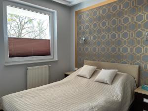 a bedroom with a bed and a window at Apartament Przy Plaży in Gdańsk