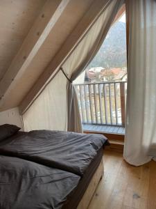 een slaapkamer met een bed en een groot raam bij Sunny Retreat Apartment in Kranjska Gora