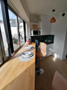 - une cuisine avec un comptoir et une table avec des assiettes dans l'établissement Vannes: charmant studio sur le port, à Vannes