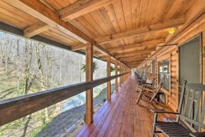 a porch of a wooden cabin with chairs on it at The Lodge Nantahala River in Bryson City
