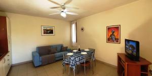 a living room with a table and a blue couch at Via Ugento Apartments - GiHome in Sant'Isidoro