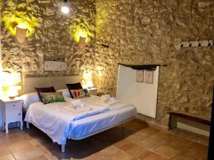 a bedroom with a bed and a stone wall at Agroturismo Can Guillo in Pollença