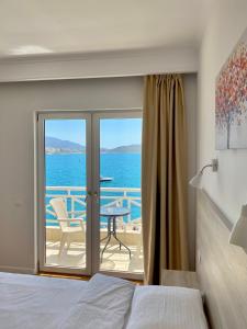 a bedroom with a bed and a view of the ocean at Sun N Blue Hotel in Sarandë