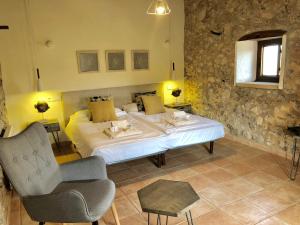 a bedroom with a large bed and a chair at Agroturismo Can Guillo in Pollença