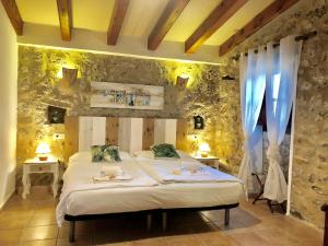 a bedroom with a bed with two tables and two windows at Agroturismo Can Guillo in Pollença
