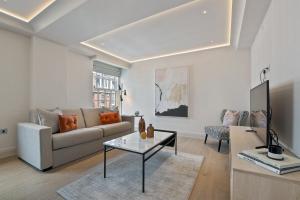 - un salon avec un canapé et une table dans l'établissement Hope House Residences by Q Apartments, à Londres
