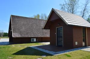 a small brown building with a gambrel roof at Intertranscoop Lake House in Vámosszabadi