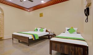 A bed or beds in a room at Treebo Trend Cecil Resort 600 Mtrs From Matheran Railway Station