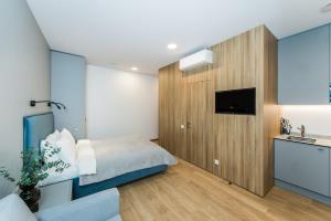 a bedroom with a bed and a sink and a tv at River city apartments No 3 by URBAN RENT in Kaunas