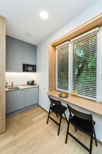 a kitchen with a table and two chairs and a window at River city apartments No 3 by URBAN RENT in Kaunas