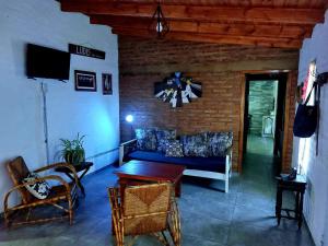 Cabaña La Nena في سانتا روزا: غرفة معيشة مع أريكة زرقاء وطاولة
