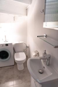 a bathroom with a toilet and a sink and a washing machine at Stylowy apartament w historycznej części Gdańska in Gdańsk