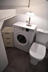 a bathroom with a washing machine and a toilet at Stylowy apartament w historycznej części Gdańska in Gdańsk