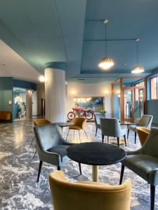a lobby with couches and tables and chairs at Hotel Astoria in Garda