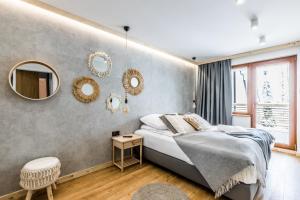 a bedroom with a bed and mirrors on the wall at Apartament Forrest Pardałówka in Zakopane