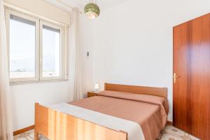 a bedroom with a bed and a window at Giardini Naxos Apartment with Terrace near the Sea in Giardini Naxos