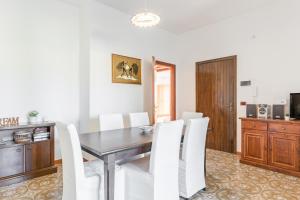 a dining room with a table and white chairs at Giardini Naxos Apartment with Terrace near the Sea in Giardini Naxos