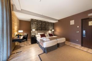a hotel room with a large bed and a large window at Castilla Termal Burgo de Osma in El Burgo de Osma