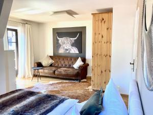 salon z kanapą i krową na ścianie w obiekcie STADTVILLA BELLE KITZ im Zentrum mit Sauna by Belle Stay w mieście Kitzbühel