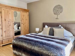sypialnia z łóżkiem i dużą drewnianą szafką w obiekcie STADTVILLA BELLE KITZ im Zentrum mit Sauna by Belle Stay w mieście Kitzbühel