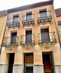 - un bâtiment avec des balcons sur le côté dans l'établissement Estrada Suites, à Ávila