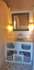 La salle de bains est pourvue d'un lavabo et d'un miroir. dans l'établissement Kasbah Azalay Merzouga, à Merzouga
