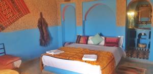 - une chambre avec un lit dans une pièce bleue dans l'établissement Kasbah Azalay Merzouga, à Merzouga
