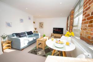 a living room with a couch and a table at Lighthouse Lofts - Godrevy in Camborne