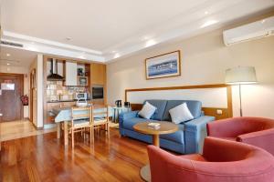 a living room with a blue couch and a table at Boca do Rio - Apartamento T1 in Lagoa