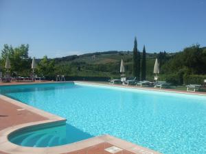 
a large swimming pool in front of a large building at Podere Il Gioiello in San Gimignano
