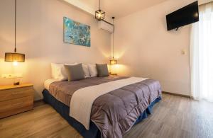 a bedroom with a bed and a tv on the wall at Sophies Greek Gateway in Kardamaina