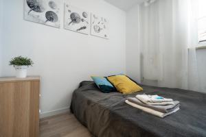 1 dormitorio con 1 cama con toallas en Ideal Apartments Grobla, en Gdansk