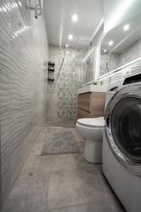 y baño con aseo y lavadora. en Ideal Apartments Grobla, en Gdansk