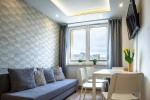 sala de estar con sofá y mesa en Ideal Apartments Grobla, en Gdansk