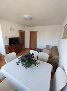 un salon avec une table blanche avec des fleurs dessus dans l'établissement Vila Kasindol, à Sarajevo