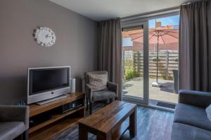 a living room with a tv and a table and chairs at Holidayhouse - - Zuidstraat 4 Zoutelande in Zoutelande