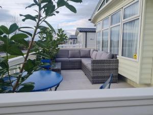 a patio with a couch and a table at Clwyd 6 in Borth