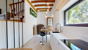 a kitchen with white counters and a sink and a window at L’Oxalis villa, Sauna et Jaccuzi privatif in Bullion