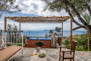 eine Pergola auf einer Terrasse mit einem Tisch und Stühlen in der Unterkunft Lotzetta Suites by Estia in Agia Galini