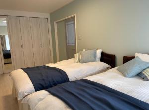 2 nebeneinander sitzende Betten in einem Schlafzimmer in der Unterkunft Holiday Villa 旅生 in Tonosho