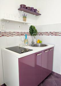 a kitchen with a sink and a purple cabinet at M&M apartment & rooms in Perast
