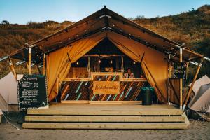 a tent with a bar in it with people in it at Beachcamp Bloemendaal Surf Resort in Overveen