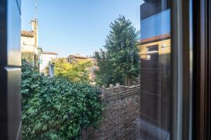 a view from a window of a brick wall and trees at Centrale appartamento per 4 persone in Venice